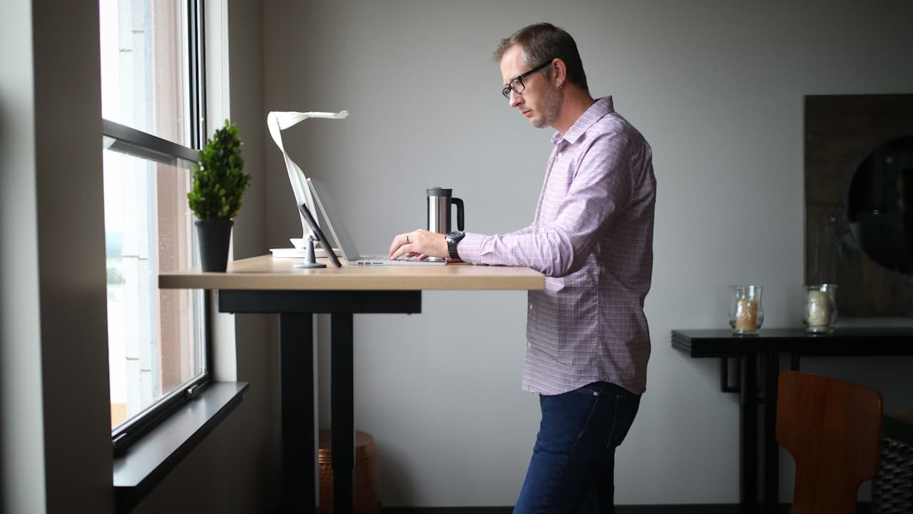 An anti-fatigue mat in front of a standing desk workstation with a person standing comfortably